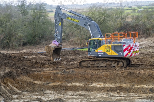TRU PLANT hire Volvo excavator heavy plant machinery constructing new reservoir, Shottisham,