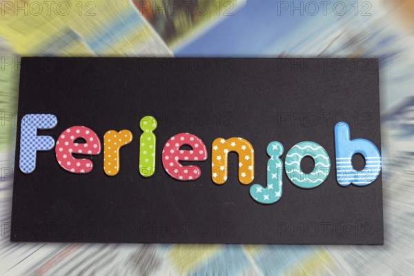 Symbolic image of a holiday job: board with the inscription FERIENJOB in front of the job adverts