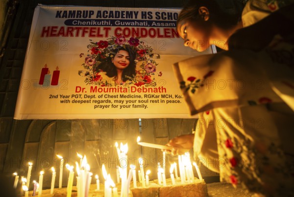 Students light candles as they pay tribute to a victim of rape and murder of a doctor inside a