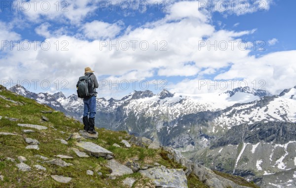 Mountaineers on a hiking trail in front of a picturesque mountain landscape, rocky mountain peaks
