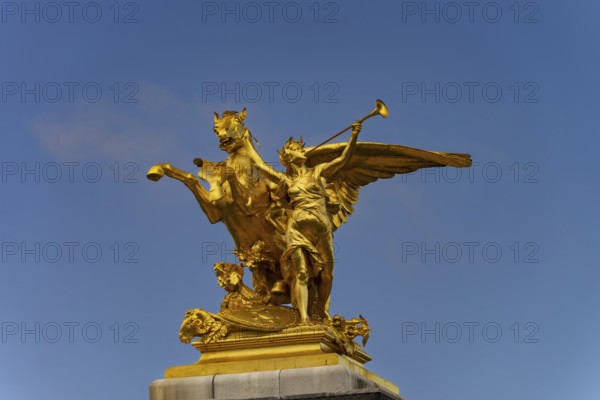 Column with the group of figures Fama of War on the Pont Alexandre III bridge over the Seine,