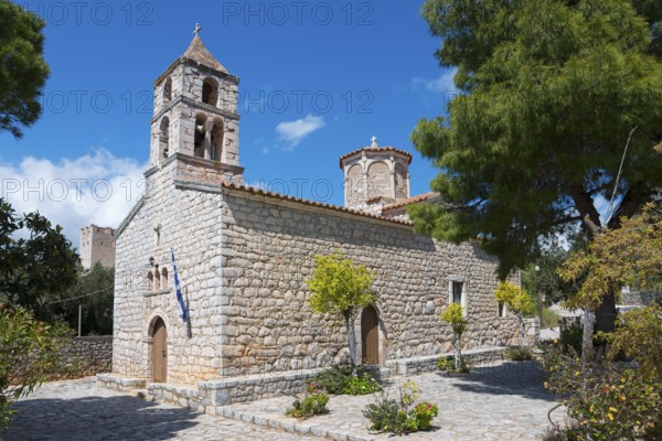 An old stone church under a blue sky surrounded by greenery, Abundant Life Church, Areopolis,