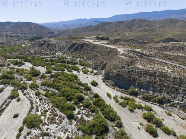 Dry landscape with hills and river valleys under a sunny sky, aerial view, Tabernas Desert,