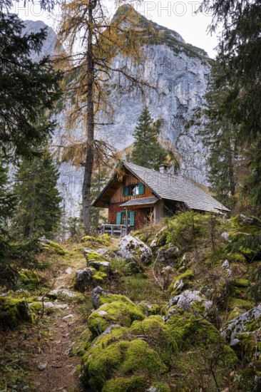 A hut in the mountains of the Gosaukamm. A path and rocks with moss. In the background a part of