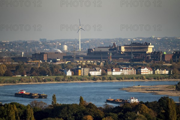 Cargo ships on the Rhine near Duisburg, houses on Deichstrasse, industrial backdrop of the