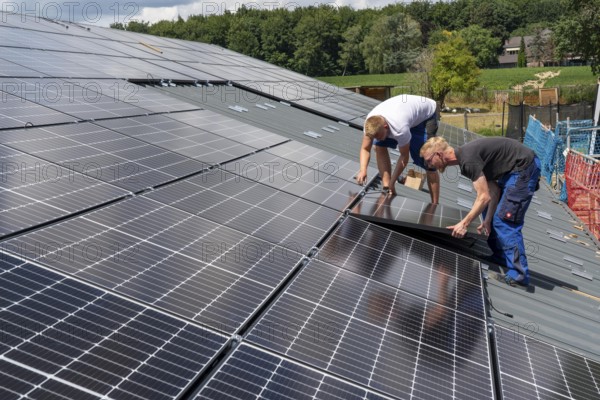 Installation of solar modules on the roof of a barn on a farm, over 210 photovoltaic modules are