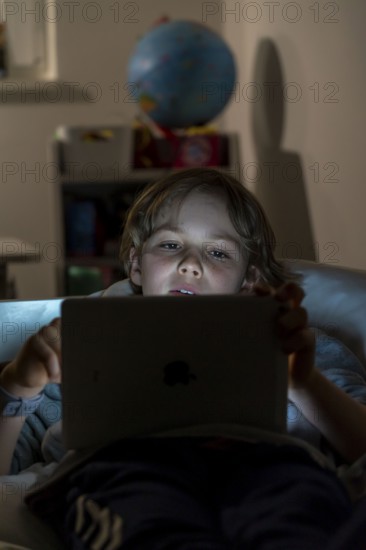 A boy plays computer games on a tablet PC