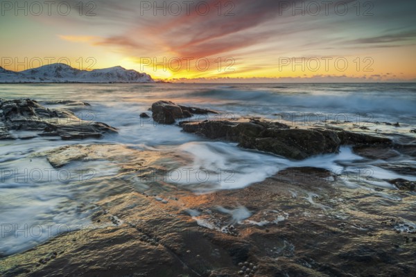 Long exposure, sunset in winter at Skagsanden, rocks washed over by the sea on the beach at
