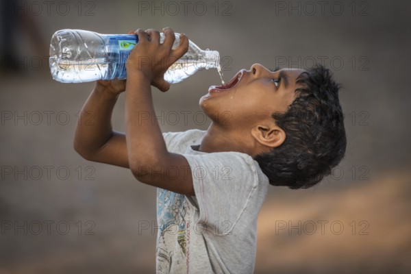 Boy drinking water from a plastic bottle, Fort Cochin, Kochi, Kerala, South India, India, Asia