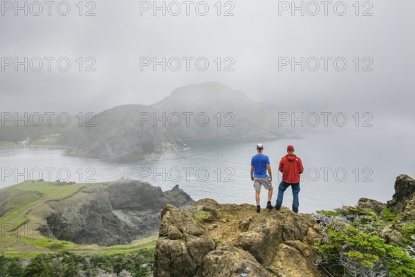 Aerial view, drone photo: Two men standing in the fog on a cliff above Bottle Cove, Bottle Cove