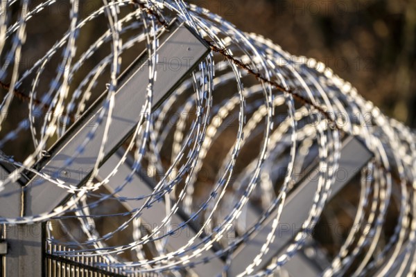 Symbolic image security, S-wire rolls, NATO wire, on a fence top, demarcation of a property,