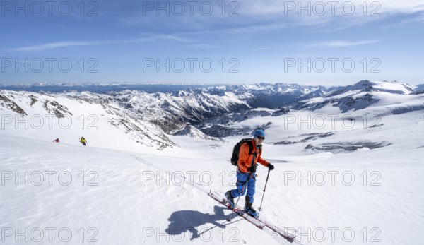 Ski tourers in front of a mountain panorama, snow-covered mountain landscape with glacier in