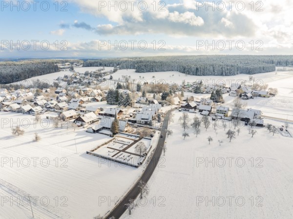 Snow-covered village with streets and buildings under a cloudy sky, Oberreichenbach, Black Forest,