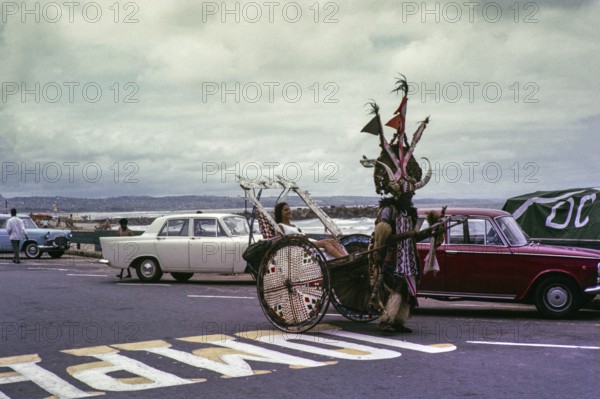 Rickshaw boy, African man taking a white woman in a rickshaw, Cape Town, South Africa 1960s