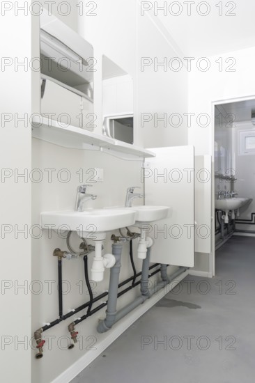 Bright bathroom with two washbasins and minimalist mirrors, refugee accommodation Beermiß,