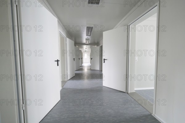 Modern, minimalist hallway with open white doors, Beermiß refugee accommodation, Calmbach, Black