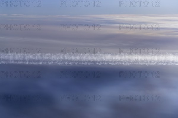 View of the Persian Gulf from the aeroplane window. Sun and clouds over the sea. Aeroplane above