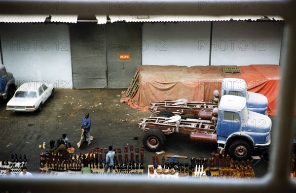 Trucks on the quay and traders with tourist souvenirs, harbour of Dakar, Senegal, West Africa,