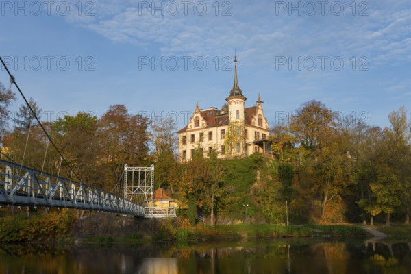 Castle on a wooded hill with adjoining bridge and river in autumn, Gattersburg Castle, suspension