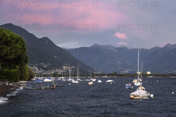Boats lying in the water, Locarno, Lake Maggiore, clouds coloured by the evening light in the