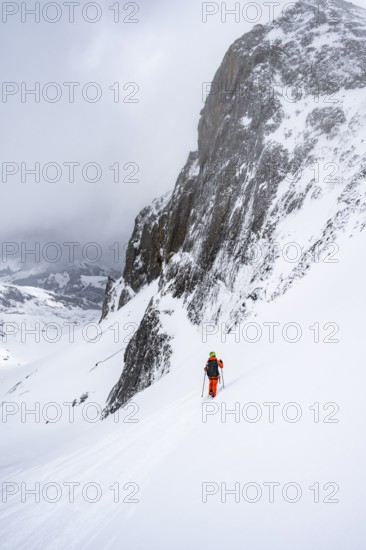 Ski tourer on a steep mountain slope, Snowy mountain landscape, Bernese Alps, Bernese Oberland,