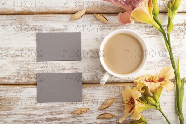 Gray paper business card mockup with orange day-lily flower and cup of coffee on white wooden