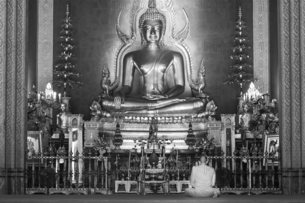 Monk meditating, Golden Buddha statue, Bhumispara-mudra, Buddha Gautama at the moment of