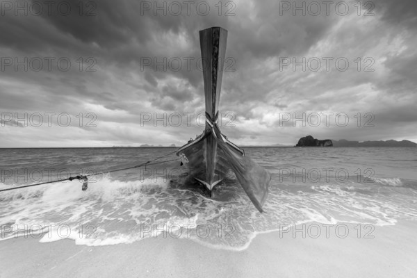 Longtail boat on the beach, dark rain clouds behind, Koh Ngai Island, Andaman Sea, Satun Province,