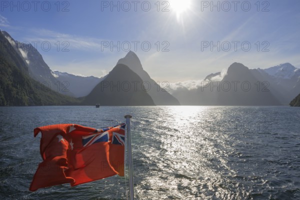 New Zealand flag waving, Milford Sound, South Island, Southland, New Zealand, Australasia, Oceania