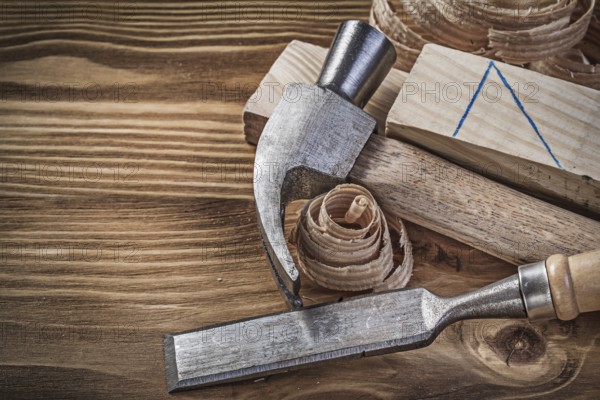 Claw hammer firmer chisel wooden studs shavings on vintage wood board