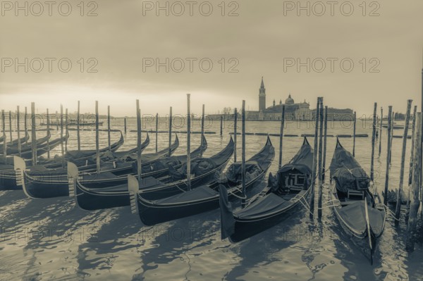 Cloudy atmosphere at sunrise, gondolas, San Giorgio Maggiore church in the background, Venice,
