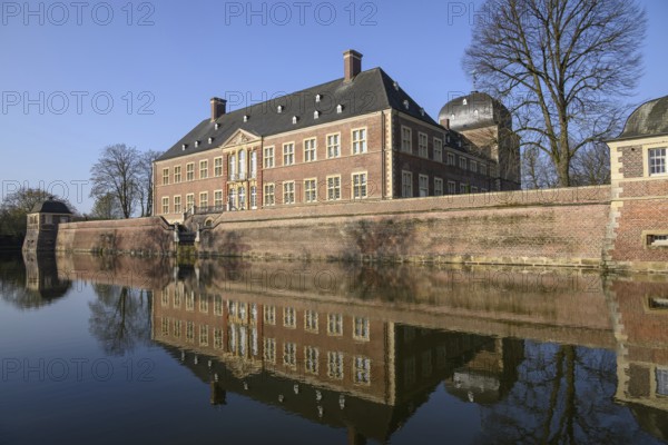 Brick castle on the water with precise reflection in the calm water, ahaus, germany