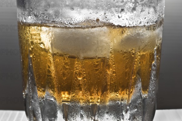 Drinks, shimmering glass of whisky with ice