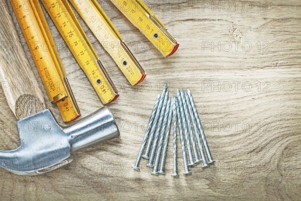 Assortment of claw hammer wooden meter construction nails on wood board building concept