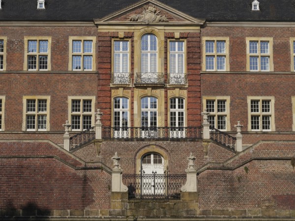 Magnificent red brick castle façade with ornate windows and symmetrical staircase, ahaus,