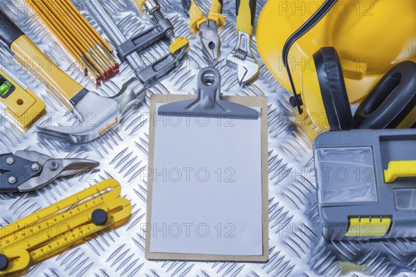 Clipboard with white sheet of paper and set construction tools