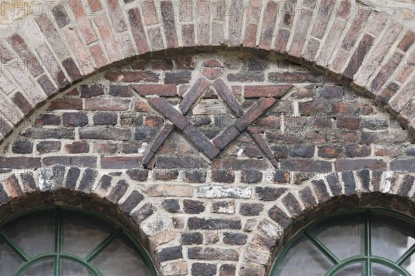 Door of the former blacksmith's workshop, wall relief with compass and drawing triangle, possibly a