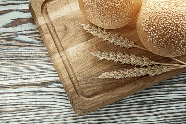 Chopping board bread wheat ears on wooden surface