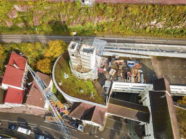 Aerial photo of a construction project with a concrete tower and surrounding streets and autumnal