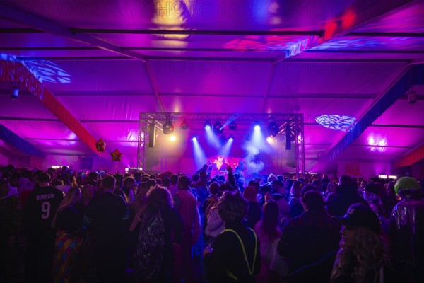 Large crowd enjoying a concert in a festively lit tent, carnival, Schlagerkuchen Donzdorf,