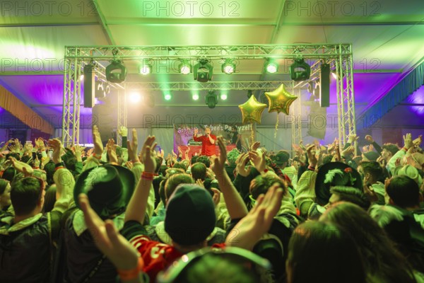 Lively concert with a cheering crowd under green spotlights, carnival, Schlagerkuchen Donzdorf,