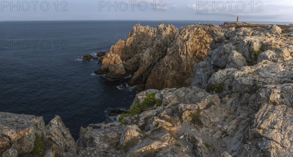 The tip of Pen Hir. The rocks are jagged and rough, the water is calm. The scenery is peaceful.
