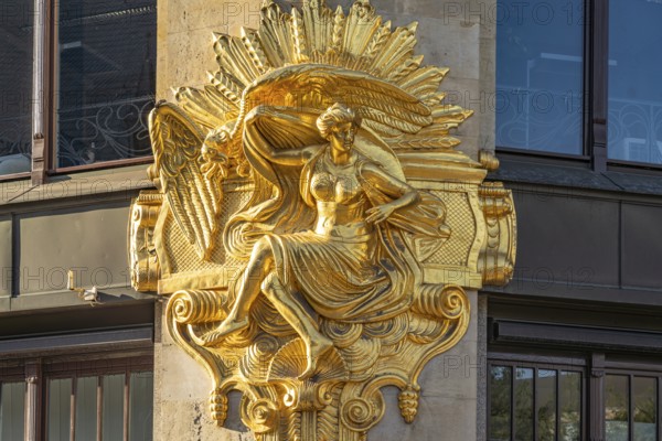 Gilded façade element with the allegory of hedonism on the former Art Nouveau department stores'