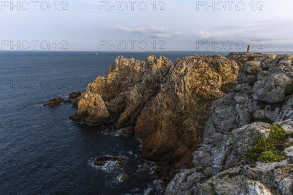 The tip of Pen Hir. The rocks are jagged and rough, the water is calm. The scenery is peaceful.