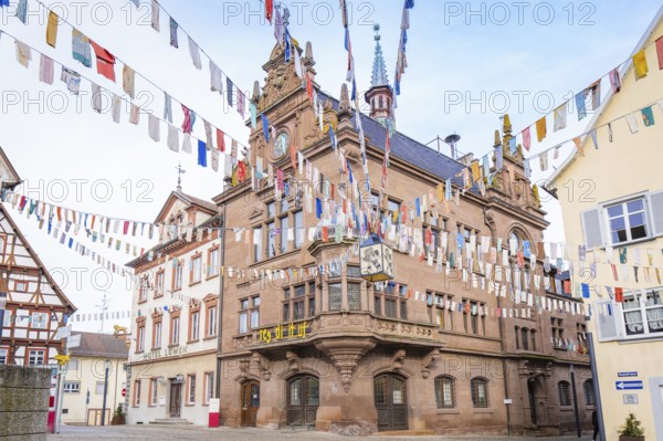 Historic building with colourful pennants and clock, surrounded by half-timbered houses, Meßkirch,