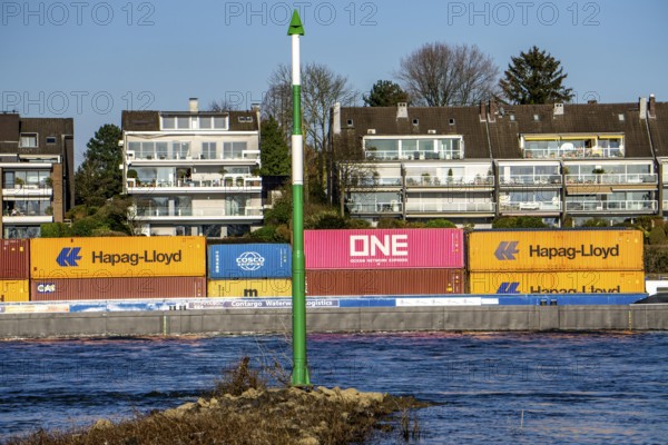 Container cargo ship on the Rhine near Düsseldorf-Bockum, villas on the banks of the Rhine, the