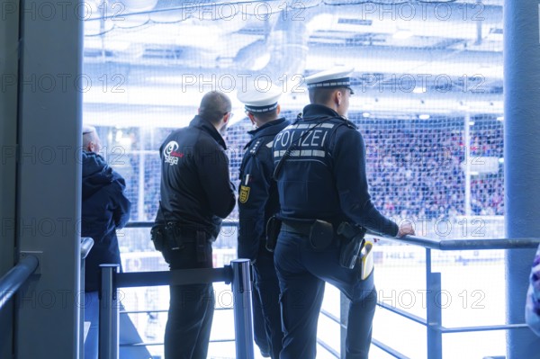 Three police officers monitor the action in an ice hockey stadium, Heilbronner Falken Vs
