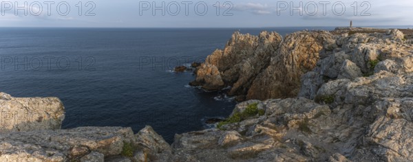 The tip of Pen Hir. The rocks are jagged and rough, the water is calm. The scenery is peaceful.