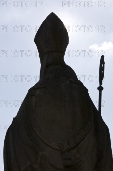 Statue of Bishop Boniface with mitre and crozier against the light, Freckenhorst, Münsterland,