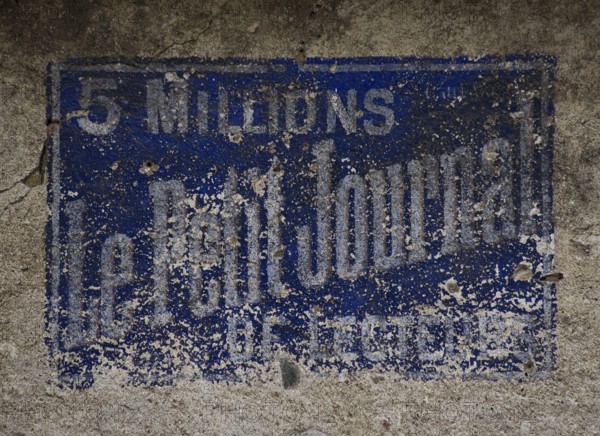 Weathered, historic wall advertisement LE PETIT JOURNAL (5 million readers) in Hérisson (Allier)